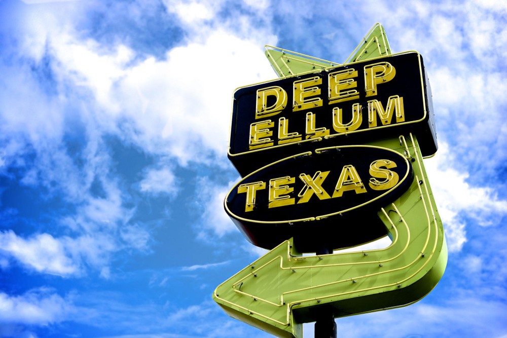 neon yellow and black sign reading "Deep Ellum Texas" 