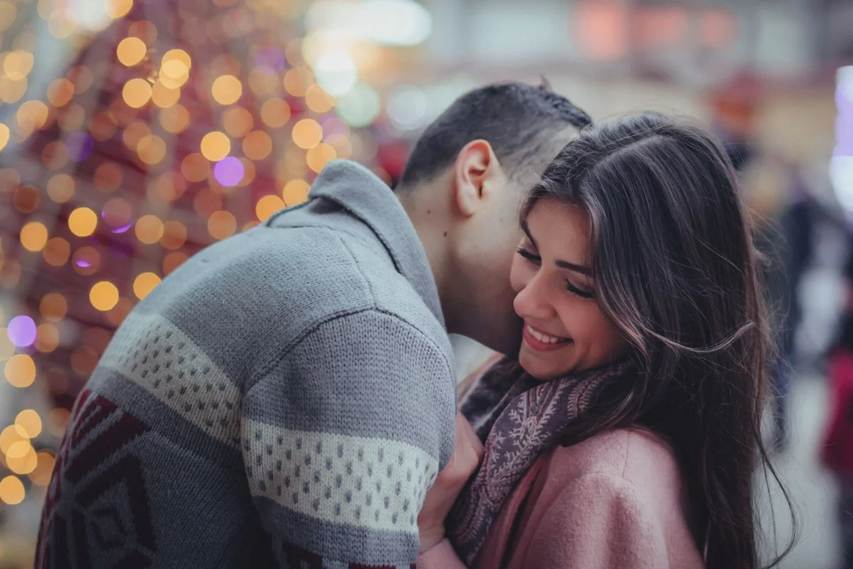 Couple enjoying a romantic moment with festive lights in the background, ideal for a date night blog post in Dallas