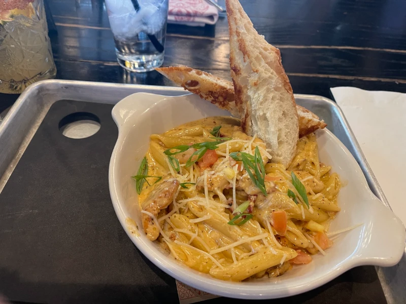 Creamy penne pasta with vegetables and bread slices at a restaurant in Downtown Las Vegas