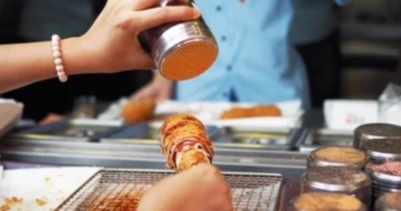 Seasoning a Korean corn dog at a Chinatown Las Vegas restaurant