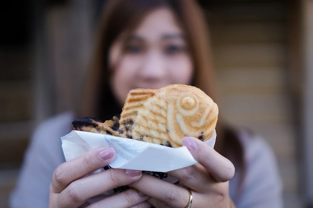 Woman holding a Taiyaki, fish-shaped cake, in Chinatown Las Vegas