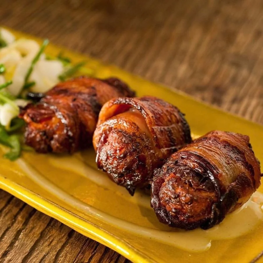 Bacon-wrapped dates on a yellow plate at a restaurant on the Las Vegas Strip.