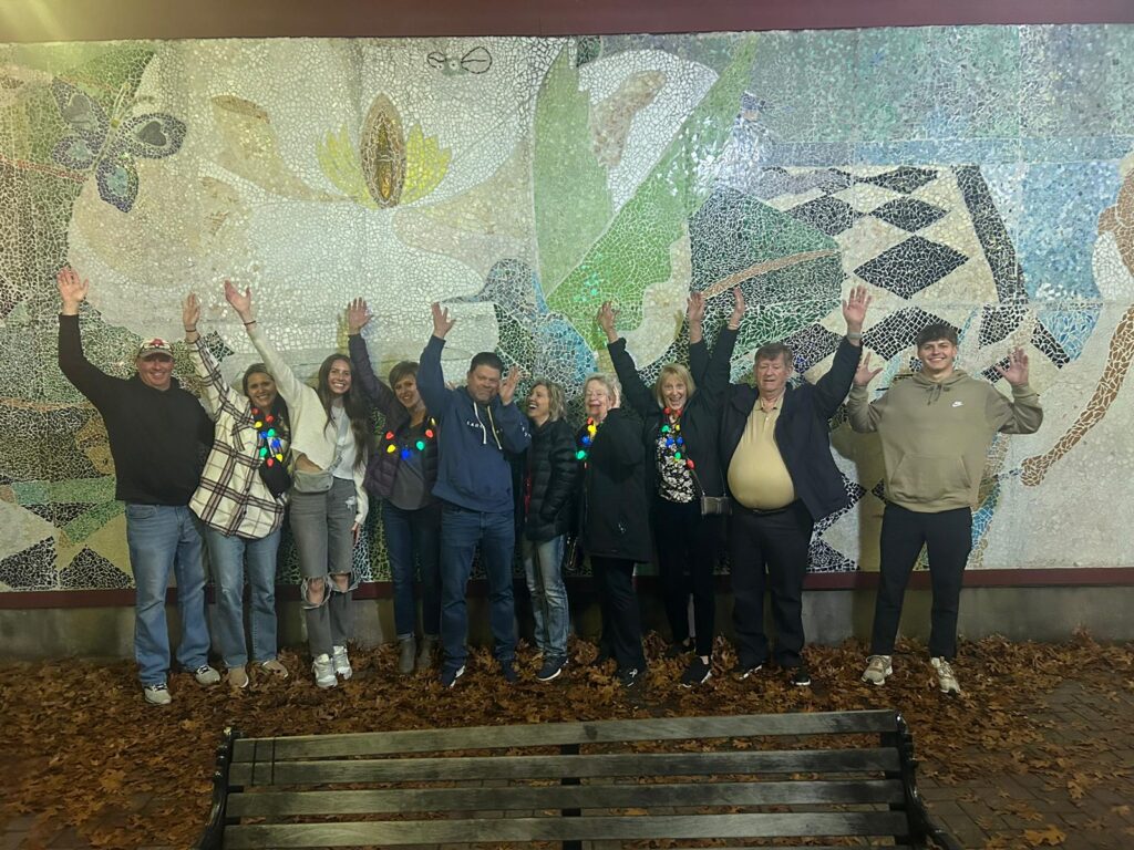 Group on a Holiday Food Tour in front of a Mural in Fort Worth
